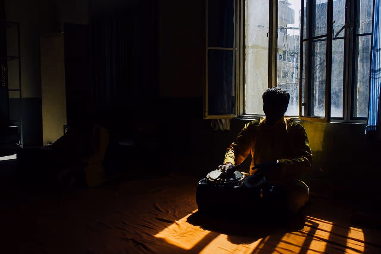 Person playing tabla at home after learning online